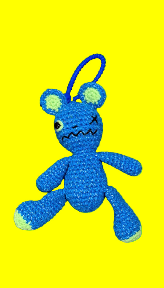 Blue plush toy with a sad expression on a green background