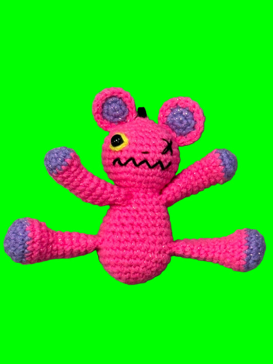 Pink and purple knitted toy on a gray surface